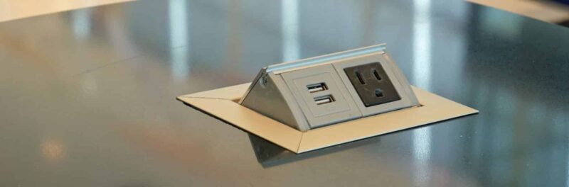 Pop-up power outlet integrated into a countertop, featuring USB ports and standard electrical sockets for convenient access to power